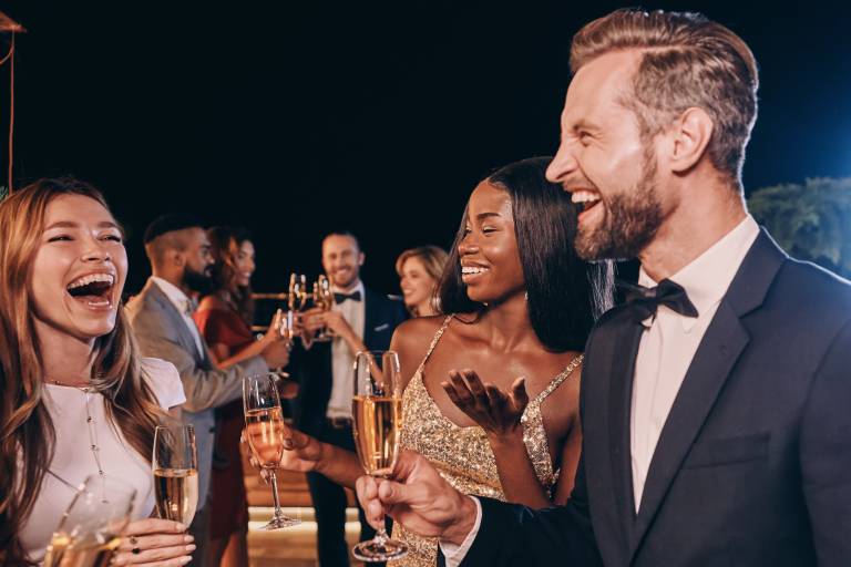 Group of beautiful people in formalwear communicating and smiling while spending time on luxury party